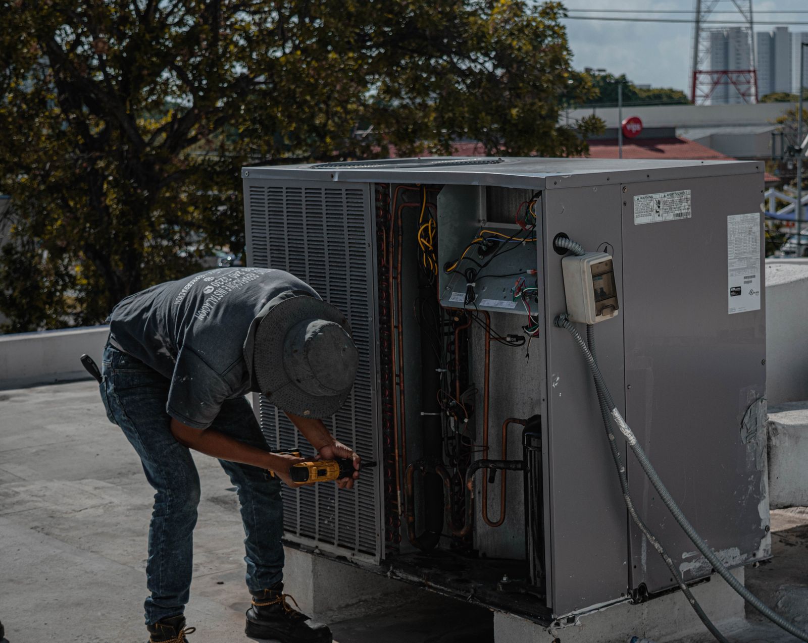 HVAC technician servicing rooftop air-conditioning equipment